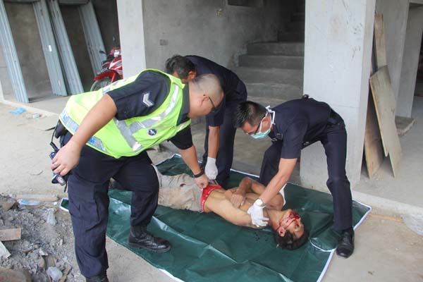 警员将死者的遗体装入尸袋，准备送往停尸房。