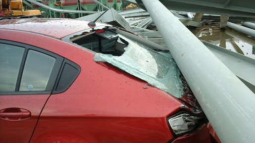 崭新轿车被钢架压毁。