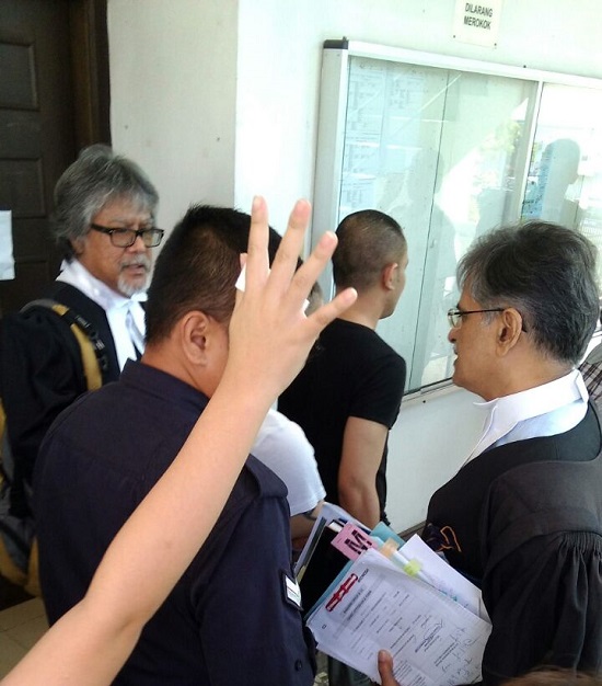 被告家属举手企图阻挡记者拍照，左为南星律师，右为拉比星。