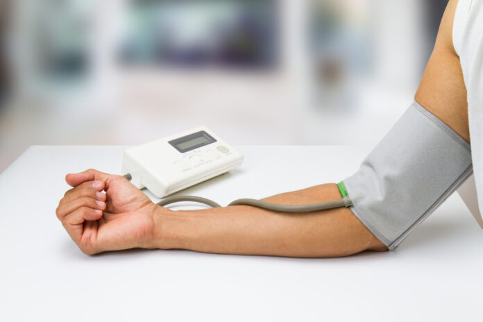 Man,Measureing,His,Blood,Pressure,On,White,Desk,At,Home