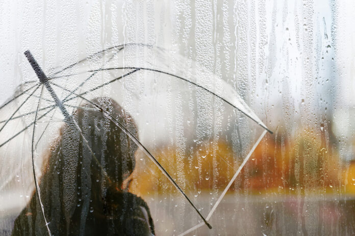 A,Woman,Silhouette,With,Transparent,Umbrella,Through,Wet,Window,With